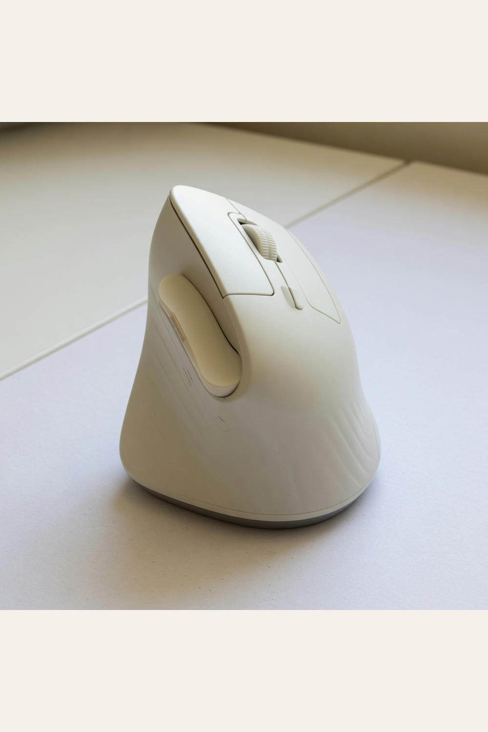off-white vertical ergonomic mouse on a desk